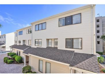 Charming multi-level townhouse with cream siding, dark window trim, and nicely maintained brick pathway at 209 75Th Ave N # T-8, Myrtle Beach, SC 29572
