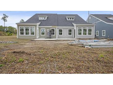 View of the backyard featuring a new patio and construction ladders near the house at 2616 Elowen Ln. # 167B, Longs, SC 29568