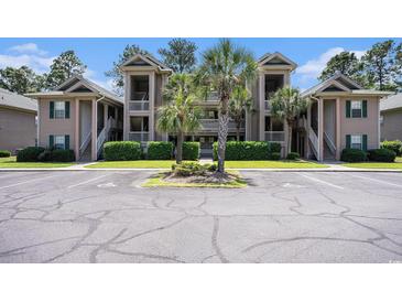 Exterior view of the condo building featuring parking and well-manicured landscaping at 342 Pinehurst Ln. # 12J, Pawleys Island, SC 29585