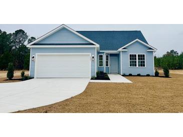 Charming single-story home featuring light blue siding, a two-car garage, and manicured front lawn at 375 Log Cabin Rd., Loris, SC 29569