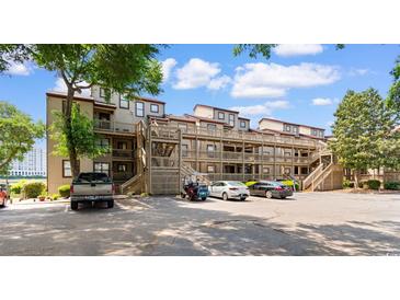 Condo exterior with multiple floors, parking, and staircase access to all units at 501 Maison Dr. # F14, Myrtle Beach, SC 29572