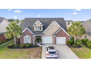 Charming two-story home with brick accents, two-car garage, well-manicured lawn, and mature palm trees at 523 Stonemason Dr., Myrtle Beach, SC 29579