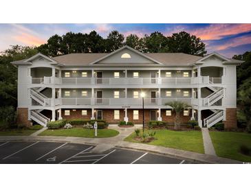 Well-maintained condo building features multiple floors and private balconies, surrounded by lush landscaping and a paved parking lot at 5750 Oyster Catcher Dr. # 333, North Myrtle Beach, SC 29582