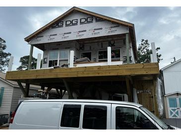New exterior construction shows a home with a deck and construction still in progress, with a construction van parked nearby at 6001 - 1766 S Kings Hwy., Myrtle Beach, SC 29575