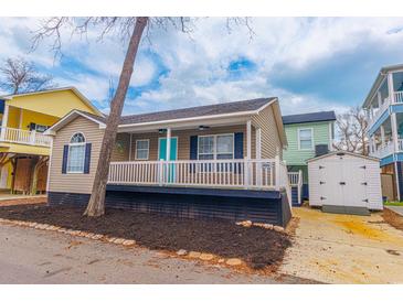 Charming home featuring a welcoming front porch and a brightly colored front door at 6001-8026 South Kings Hwy., Myrtle Beach, SC 29575