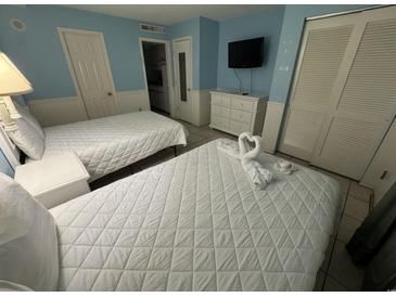 Cozy bedroom featuring two beds, a dresser, and a mounted TV at 7500 N Ocean Blvd. # 6120, Myrtle Beach, SC 29572