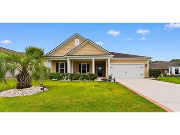 Charming tan home featuring a well-manicured lawn, complemented by a two-car garage and inviting front porch at 1035 Brentford Pl., Myrtle Beach, SC 29579