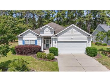 Charming one-story home with manicured lawn, two-car garage, and beautiful landscaping at 205 Carriage Lake Dr., Little River, SC 29566
