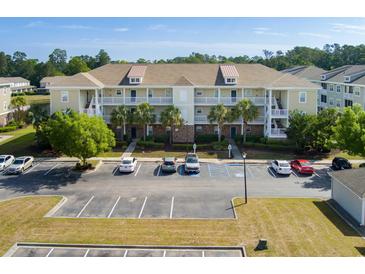 Two-story condo with balconies, palm trees, and a large parking area at 334 Kiskadee Loop # 18-L, Conway, SC 29526