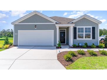 Charming single-Gathering home features a two-car garage and landscaped front yard at 493 Blissful Ln., Little River, SC 29566