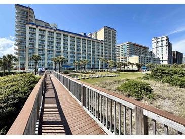 A captivating view of the resort from the wooden boardwalk with buildings and clear skies at 5200 N Ocean Blvd. # 640, Myrtle Beach, SC 29577