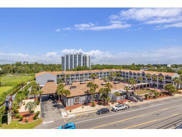 Beautiful multi-story hotel features a lush marshy green space and various palm trees at 6803 N Ocean Blvd. # 228, Myrtle Beach, SC 29572