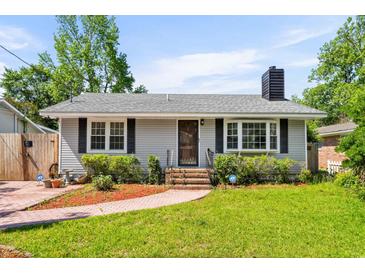 Charming single-story home with a well-manicured lawn, brick walkway, and classic design elements at 719 Juniper Dr., Myrtle Beach, SC 29575