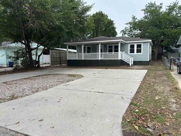 Charming single-story home with a spacious driveway and inviting front porch, perfect for relaxation at 803 34Th Ave. S, North Myrtle Beach, SC 29582