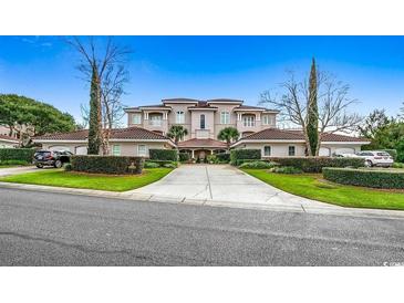 Stunning multi-story home with manicured landscaping, a private driveway, and multiple car garages on a sunny day at 8546 San Marcello Dr. # 1-102, Myrtle Beach, SC 29579