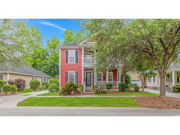 Inviting two-story home featuring a double porch, red siding and well-manicured landscaping at 212 Greenwich Dr., Conway, SC 29526