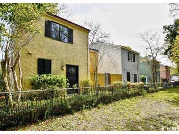 Charming exterior view of townhomes with black shutters and well-kept lawns at 217 N Myrtle St. # 1, Myrtle Beach, SC 29577