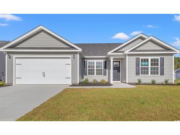 Charming single-story home featuring a two-car garage, and manicured lawn with inviting curb appeal at 271 Stillbrook Dr., Longs, SC 29568