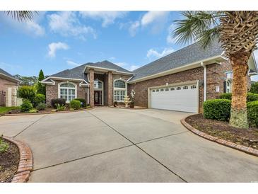 Brick home featuring an attached two-car garage, front fountain, mature landscaping, and concrete driveway at 372 Waterfall Circle, Little River, SC 29566