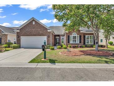 Charming brick home with well-maintained landscaping, a green lawn, and an attached two-car garage at 3802 Seedling Ct., North Myrtle Beach, SC 29582