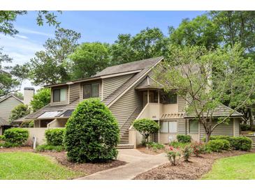 Two-story condo features beautiful landscaping, stairs to the front door, and neutral toned siding at 400 Melrose Pl. # 14E, Myrtle Beach, SC 29572