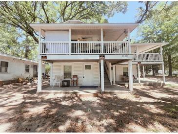 Two-story home featuring double porches, white railings, and a welcoming entrance at 401 Alder St., Myrtle Beach, SC 29577