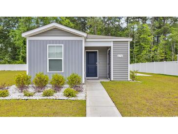 Charming home featuring stylish gray siding, a vibrant blue front door, and meticulously arranged landscaping at 478 Samara Dr., Longs, SC 29568