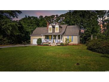 Charming single-Gathering home featuring a manicured lawn, attached garage, and inviting front porch at 645 Boundary Line Dr. Nw, Calabash, NC 28467