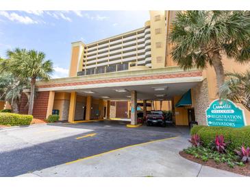 View of the building entrance with covered parking and well-maintained landscaping at 6900 N Ocean Blvd. # 710, Myrtle Beach, SC 29572