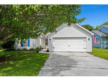Charming home featuring an attached two-car garage, lush lawn, and mature tree at 9607 Kings Grant Dr., Murrells Inlet, SC 29576