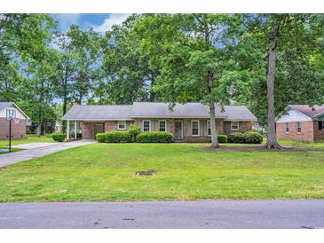 Charming single-story brick home featuring a well-manicured lawn and mature shade trees at 1108 Chicora Blvd., Conway, SC 29526