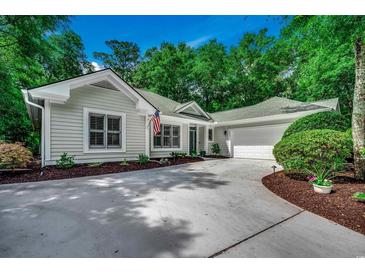 Charming one-story home featuring a concrete driveway and attached two-car garage nestled among mature trees at 1204 Pine Valley Rd., North Myrtle Beach, SC 29582