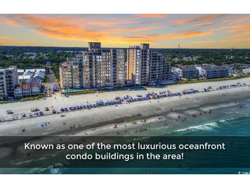 Luxurious oceanfront condo building on a sandy beach with ocean views and a beautiful sunset at 1620 N Waccamaw Dr. # 103, Garden City Beach, SC 29576