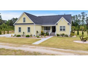 Charming yellow two-story home with landscaped yard and inviting front porch at 1763 Hemingway Rd., Loris, SC 29569