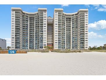 Stunning exterior view of a high-rise condo building on a sandy beach under a clear blue sky at 201 Ocean Blvd. S # 1505, North Myrtle Beach, SC 29582