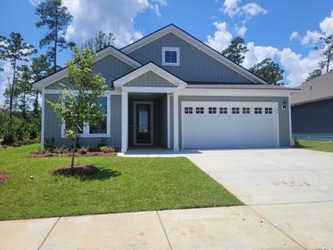 Charming single-story home with a two-car garage and a well-manicured lawn on a beautiful sunny day at 279 River Edge Dr., Myrtle Beach, SC 29588