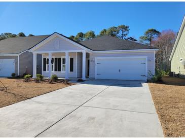 Charming one-story home featuring a front porch, a two-car garage, and a well-manicured yard at 507 Magnolia Terrace Dr, Myrtle Beach, SC 29579