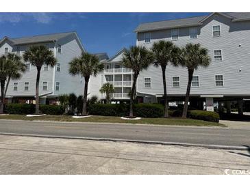 Condos featuring neatly landscaped grounds and mature palm trees on a clear sunny day at 6103 N Ocean Blvd. # C-6, North Myrtle Beach, SC 29582