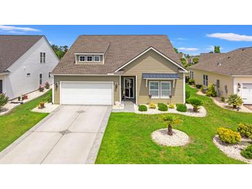 Charming single-Gathering home boasts a well-manicured lawn, attached garage, and inviting entrance at 802 Devon Estate Ave., Myrtle Beach, SC 29588