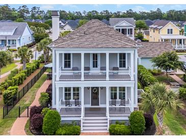 Charming two-story home featuring double porches, columns, and manicured landscaping at 8185 Sandlapper Way, Myrtle Beach, SC 29572