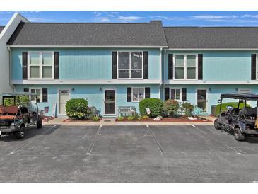 Charming condo with a well-kept exterior and golf carts in the parking area at 843 Villa Dr. # 843, North Myrtle Beach, SC 29582