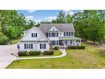 Stunning two-story home with a welcoming front porch and manicured landscaping at 856 W Highway 9, Longs, SC 29568