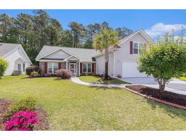 Charming single-Gathering home with lush green lawn, manicured landscaping and a driveway at 1105 Lampwick Ln., Murrells Inlet, SC 29576