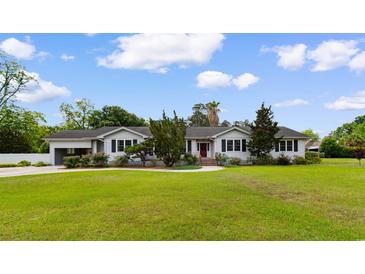 Charming single story home with lush landscaping and a well-maintained lawn on a sunny day at 115 Ford Ave, Mullins, SC 29574