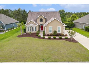 Charming home featuring a manicured lawn, mature trees, and a welcoming red front door at 1367 Bermuda Grass Dr., Myrtle Beach, SC 29579