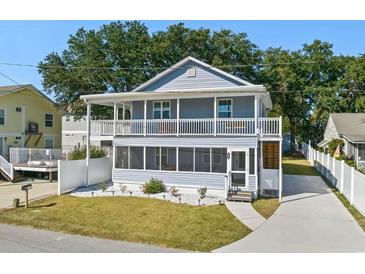Charming two-story home featuring double balconies, a screened-in porch, and a well-manicured lawn at 1622 Havens Dr., North Myrtle Beach, SC 29582