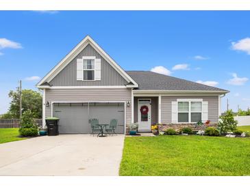 Charming two-story home with gray siding, an attached garage, and a well-manicured front yard with green lawn at 232 Red Maple Loop, Longs, SC 29568