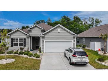 Charming one-story home featuring a two-car garage, well-manicured lawn, and attractive gray siding at 251 Juniata Loop, Little River, SC 29566