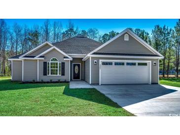 Charming single-story home featuring a two-car garage, well-manicured lawn, and classic architectural details at 2690 Hugo Rd., Conway, SC 29527