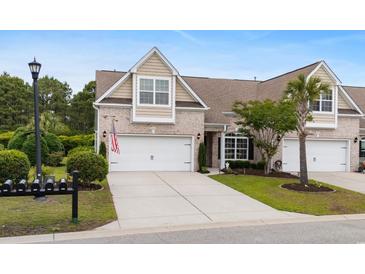 Charming two-story home features a well-manicured lawn and an attached two-car garage with an American flag displayed at 3334 Volterra Way # 3334, Myrtle Beach, SC 29579
